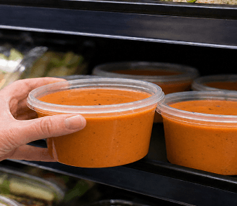 Portioned cups of chef-crafted sauce on a production rack